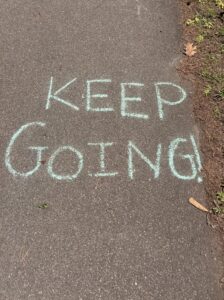 SIGUE ADELANTE escrito con tiza en el camino del corredor verde