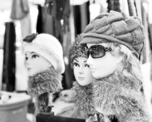 Celebrating World Photography Day with "The Gossips" a black and white photograph showing mannequin heads wearing knit caps. The mannequin in front also wears sunglasses.